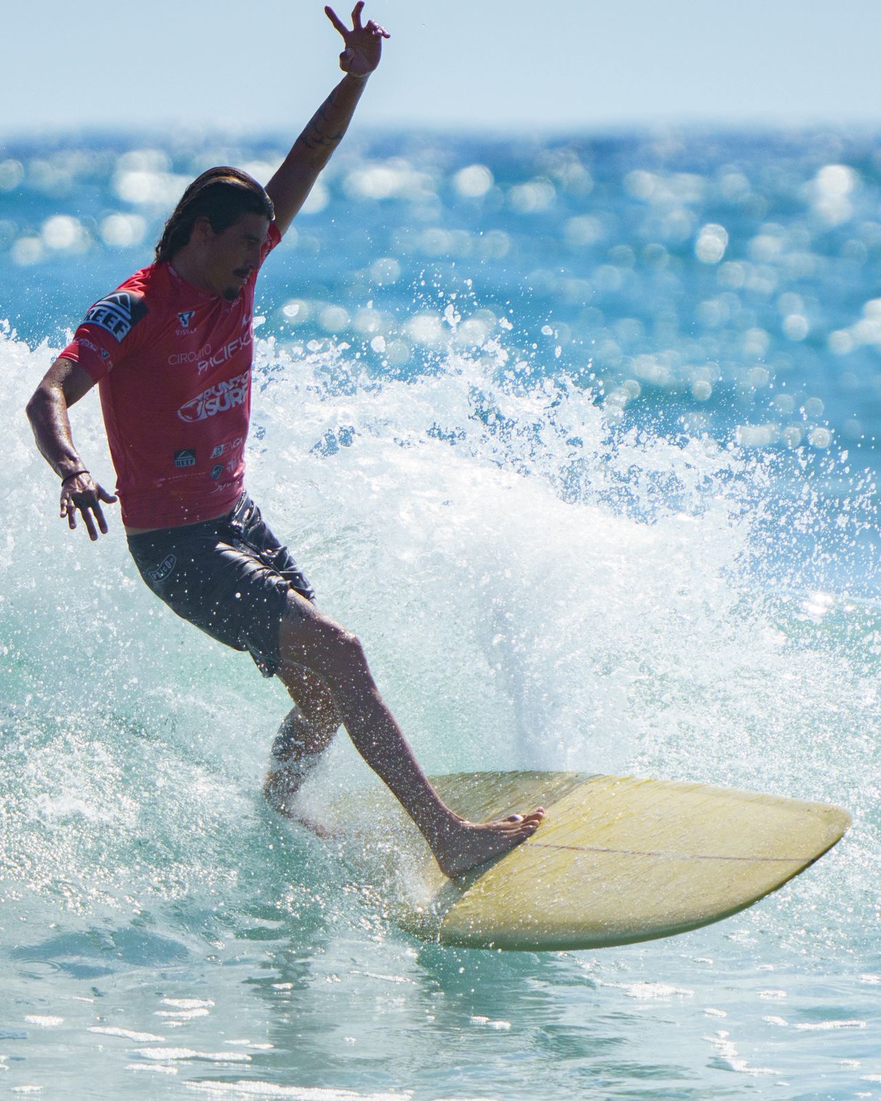 Chelo performing a power turn on a yellow shortboard